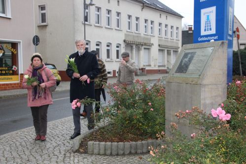 Stellvertretende Bürgermeisterin Monika Maßwig und Pfarrer i.R. Norbert Littig legen Blumen am Gedenkstein der Familie Schönwald nieder.